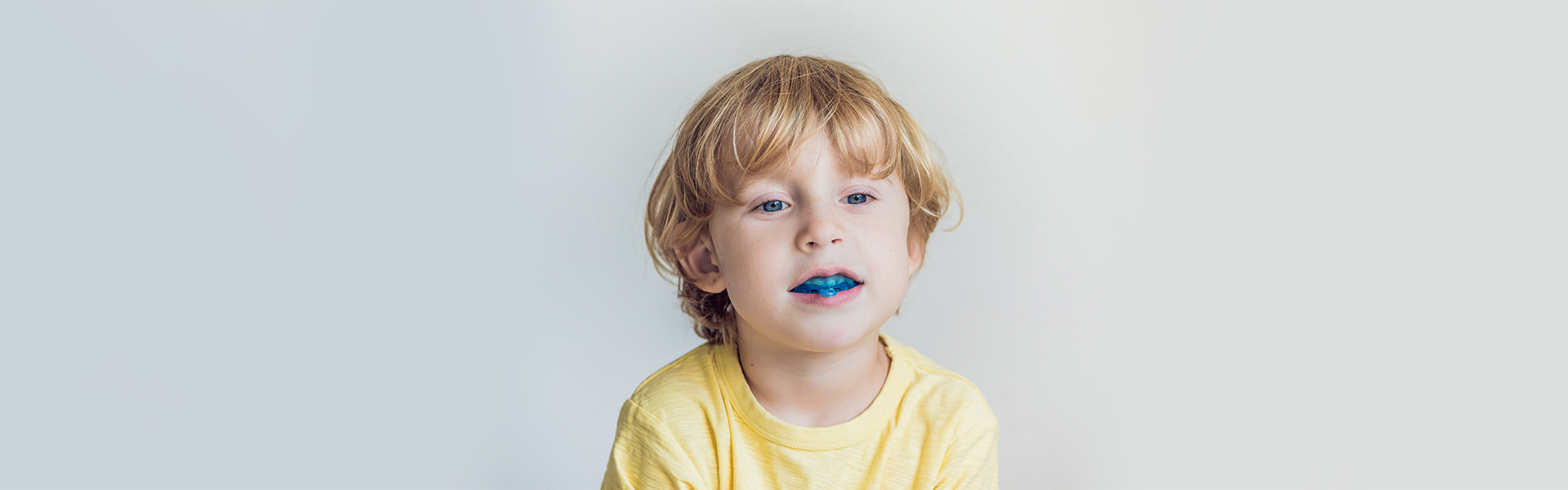 School starts soon. Plan ahead with fluoride treatments for extra protection, and a quality mouth guard, like this young girl is wearing while giving two thumbs up